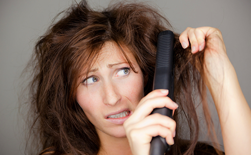 Женщина пытается расчесать плохие волосы
